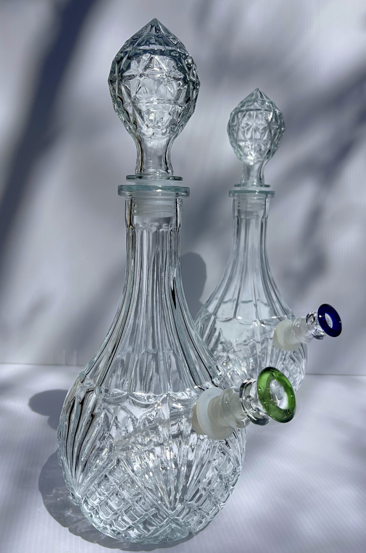 Decorative glass decanter with intricate design on a neutral background